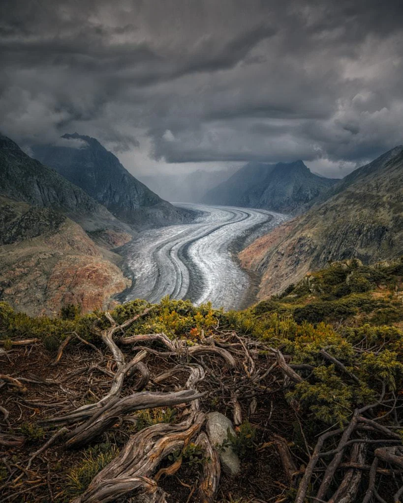 A glacier winding through a dramatic mountain valley
